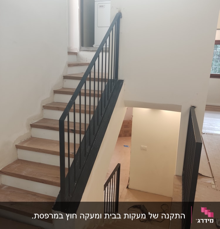 מעקה מתכת שחור על מדרגות עץ
